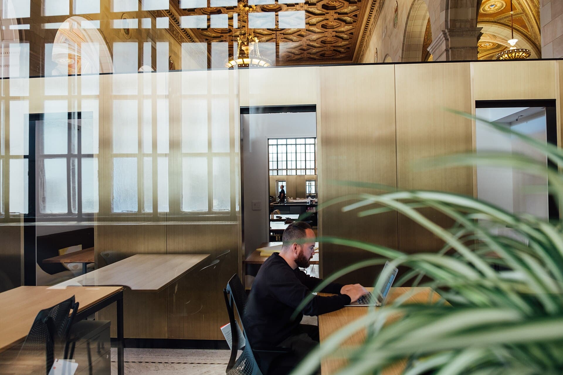 Bright open-plan office with a person working at a desk
